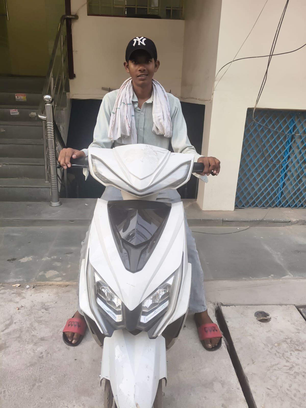 Ozoride rider on white electric scooty in city market